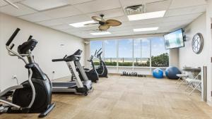 a gym with treadmills elliptical machines and a ceiling fan at Mama's Little House in Virginia Beach