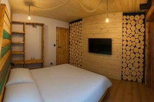 a bedroom with a bed and a wall of logs at Chatka Wagabundy in Wola Michowa
