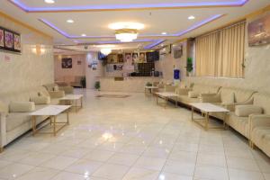 - une salle d'attente avec des canapés et des tables dans l'établissement فندق جواد الحرم الفندقية, à Az Zahrāʼ