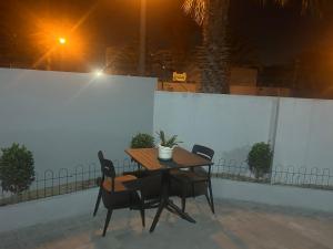 a wooden table and chairs with a potted plant on it at Ocean Whisper Room 6 minutes away from the beach in Cape Town