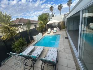 a patio with chairs and a swimming pool at Ocean Whisper Room 6 minutes away from the beach in Cape Town