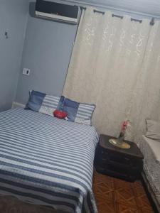 a bedroom with a bed with blue and white stripes at Pousada Pôr do Sol in Belém