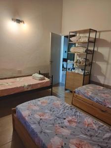 a room with two beds and a shelf of clothes at Beautiful Quinta in Corrientes in Paso de la Patria