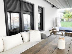 een woonkamer met een witte bank en een houten tafel bij Petite Mansion in Nasicz