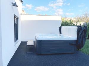 een hot tub aan de zijkant van een gebouw bij Petite Mansion in Nasicz