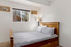 ein Schlafzimmer mit einem Bett mit weißen Laken und einem Fenster in der Unterkunft Sweet Cabin Home Gateway #2576 in Sugarloaf