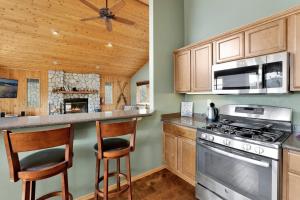 a kitchen with wooden cabinets and a stove top oven at Moonridge Treehouse #2570 in Big Bear Lake +13 photos