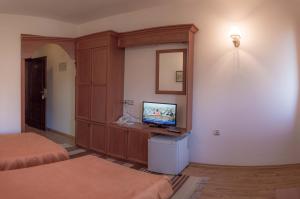 a room with two beds and a television on a cabinet at Sivrieva House in Zlatograd