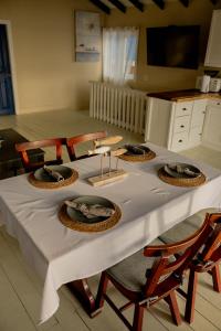 Una mesa con cuatro sillas y un mantel blanco. en West end inn, en Roatan 6 fotos más