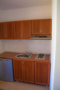 a kitchen with wooden cabinets and a sink and a stove at Sivrieva House in Zlatograd +18 photos