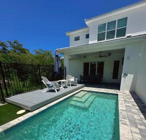 a swimming pool with chairs and a house at Lala at the Beach 512 in Chicken Island
