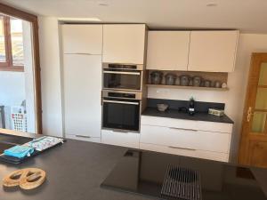 a kitchen with white cabinets and a counter top at La Belle Mélusine in Bergheim +7 photos