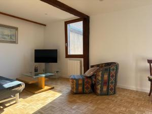 a living room with a couch and a tv at La Belle Mélusine in Bergheim