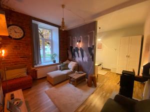 een woonkamer met een bank en een klok aan de muur bij Apartment Kopli 78 in Tallinn