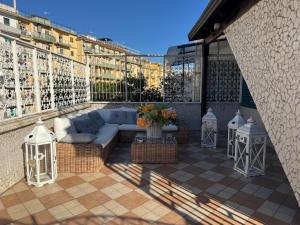 eine Terrasse mit einer Couch und einigen Tischen und einigen Gebäuden in der Unterkunft Yoyo House Luxury Napoli in Neapel