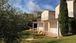 a house with a patio and chairs in the yard at Hotel Santo Stefano in Portoferraio