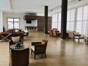 a lobby with chairs and a piano in a building at Stylish Home via a Samborondon in Estancia Vieja +8 photos