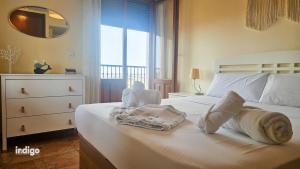 Un dormitorio con una cama blanca con toallas. en Impresionates vistas, 2 Dormitorios JUL01, en Ayamonte