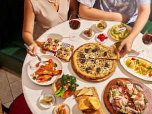 a group of people sitting at a table with plates of food at Fairmont Singapore in Singapore