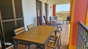 Una mesa y sillas de madera en un balcón. en Impresionates vistas, 2 Dormitorios JUL01, en Ayamonte