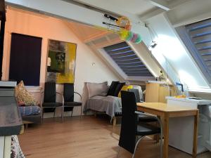 a living room with a couch and a table at Zolderstudio dichtbij Goffert met eigen badkamer en WC, eigen keuken, eigen ingang in Nijmegen