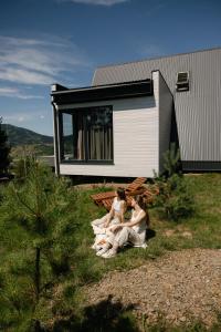two women sitting on a bench in front of a house at Лісогори in Slavske +49 photos