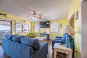 キル・デビル・ヒルズにあるT.L. Seaの青いソファ2つとテーブルのあるリビングルーム