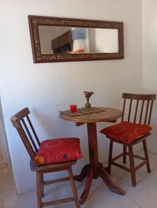 un tavolo e due sedie con tavolo e specchio di Kitnet no centro da vila a Mata de Sao Joao