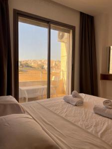 een slaapkamer met een bed en een groot raam bij Apartment - Elegance, modernity and proximity in Tanger