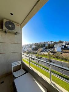 een balkon met een bank en uitzicht op een straat bij Apartment - Elegance, modernity and proximity in Tanger