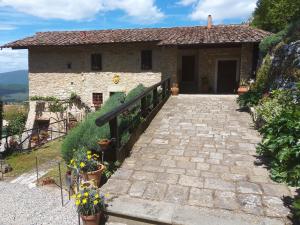 a stone house with a staircase leading up to it at Tenuta Lonciano in Gualdo
