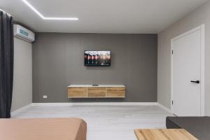 a bedroom with a tv on a wall at Luxury Apartment Lushpy Avenue - Hotel Standard in Dobrovelychkivka