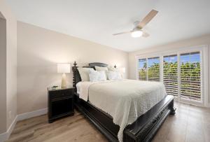 a bedroom with a bed and a ceiling fan at Surfside 12 A4 in Sanibel +53 photos