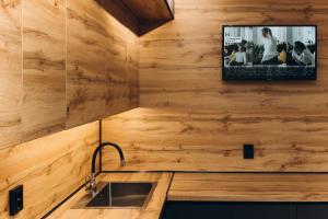 a kitchen with a sink and a tv on the wall at Luxury Apartment Lushpy Avenue - Hotel Standard in Dobrovelychkivka +17 photos