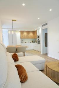 ein Wohnzimmer mit weißen Möbeln und eine Küche in der Unterkunft Serendipia Suite in Granada