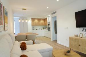 ein Wohnzimmer mit einer weißen Couch und einer Küche in der Unterkunft Serendipia Suite in Granada