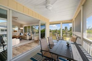 a screened in porch with a table and chairs at Surfside 12 A4 in Sanibel