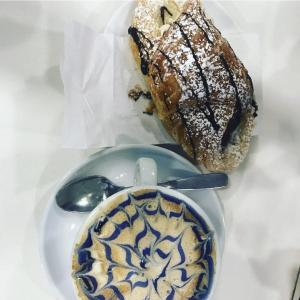 a plate with a cup of coffee and a bread at Roxy's Home in Rome in Rome +25 photos