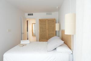 ein weißes Schlafzimmer mit einem großen weißen Bett mit zwei Kissen in der Unterkunft Serendipia Suite in Granada