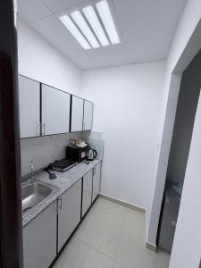 biała kuchnia ze zlewem i świetlikiem w obiekcie Studio M4 w Abu Zabi