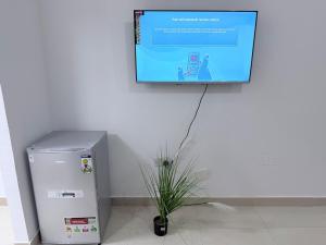 Telewizor wiszący na ścianie obok lodówki w obiekcie Studio M4 w Abu Zabi