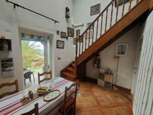 a dining room with a staircase and a table at Gurbialde Etxea in Mutriku +12 photos