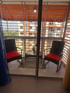 un balcón con 2 sillas y una mesa en una ventana en Comfort and tranquility in one place, en La Estrella