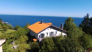 a house on a hill with the ocean in the background at Gurbialde Etxea in Mutriku