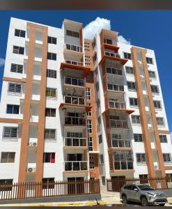 a tall apartment building with a car parked in front at Comfort and tranquility in one place in La Estrella