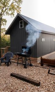 a black building with a grill and a smoker at Camptown Cabin in Eagle Rock
