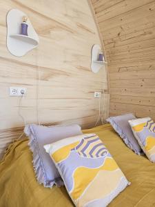 a bedroom with a bed with two pillows on it at Tiny House De Hagekrûper in Westergeest