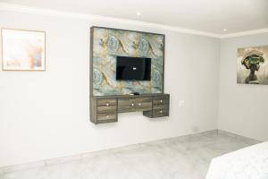 a room with a tv on a wall at Silver Lake Lodge Rustenburg in Rustenburg