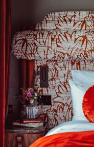 een slaapkamer met een bed met een rood en wit hoofdeinde bij 1.75 Paris La Trêve in Parijs