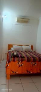 a bedroom with a bed with a colorful blanket at Dewenten Backpacker II in Tulamben